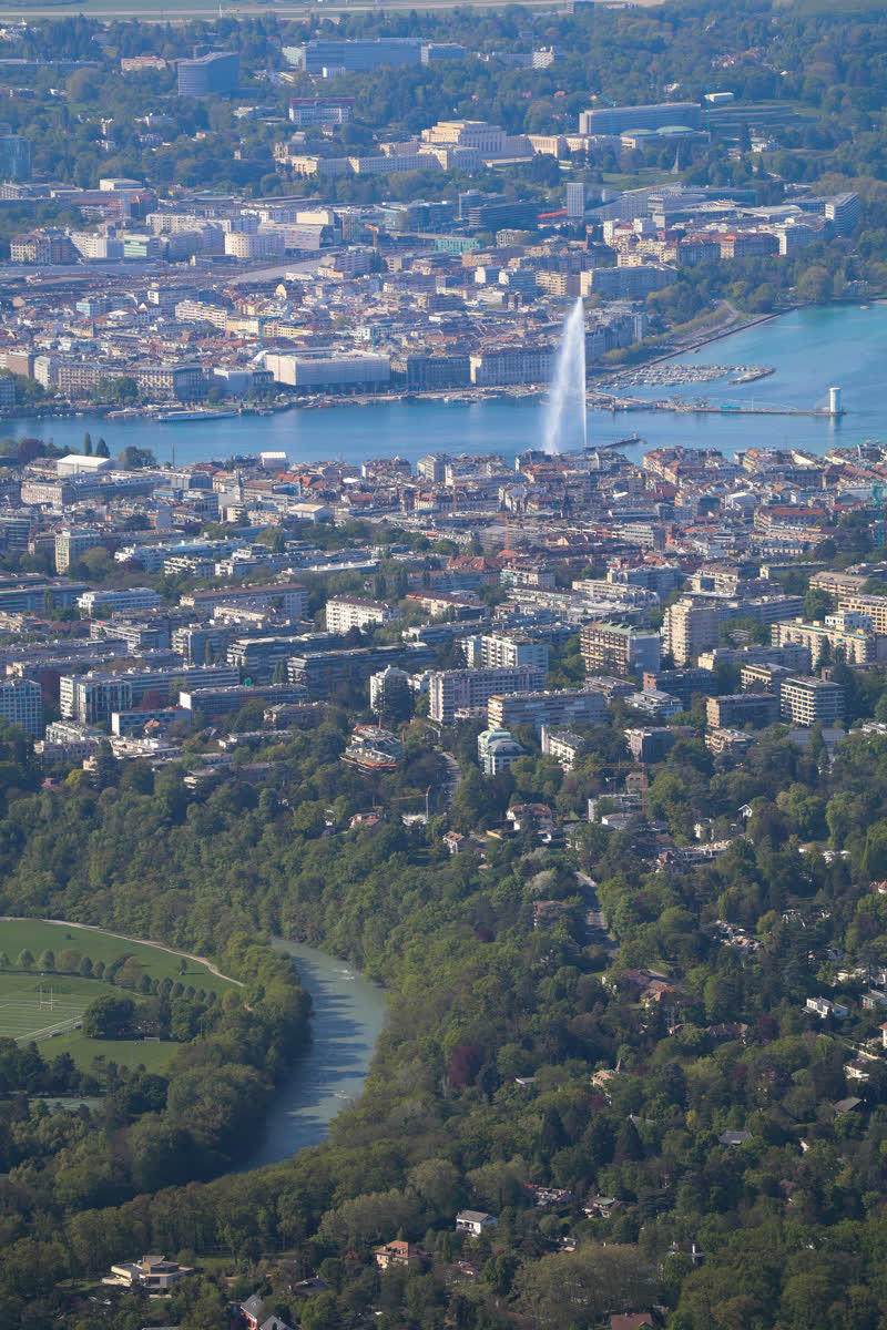 Vue aérienne de Genève depuis les hauteurs : la rade, le Jet d’eau et l’Arve.